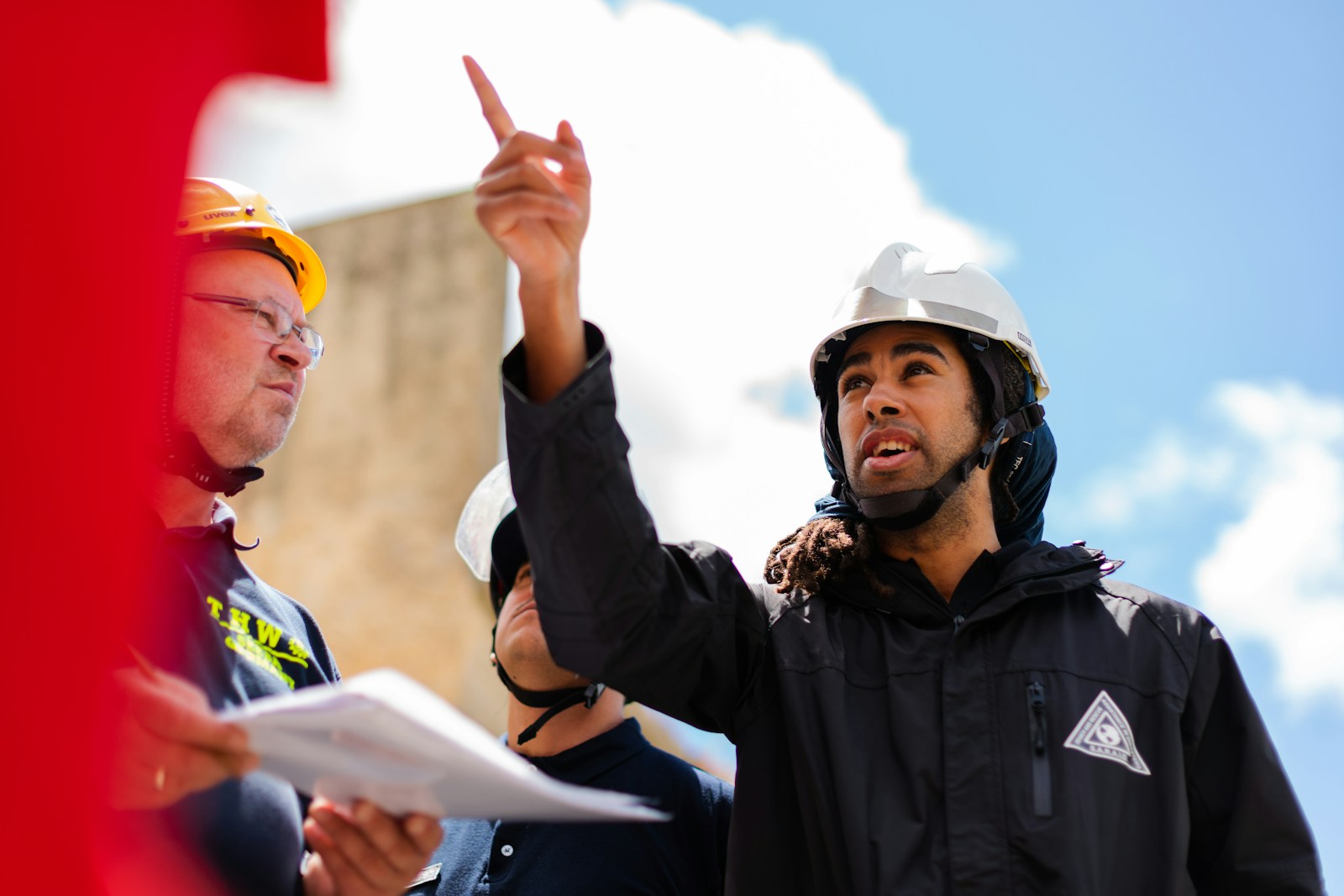 man in black jacket wearing yellow hard hat